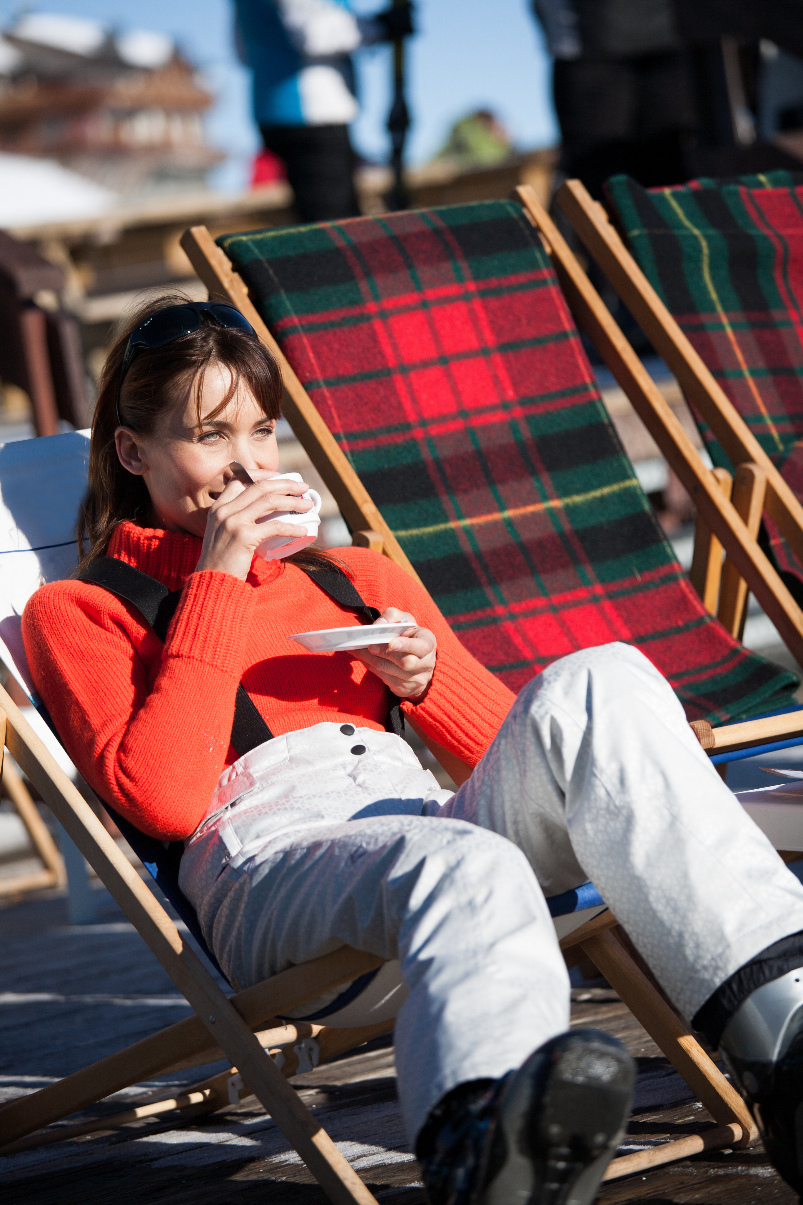Woman drinking cup of coffee in ski apparel