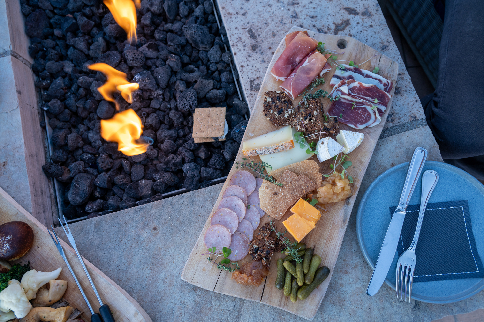 Charcuterie board and smores beside a fire